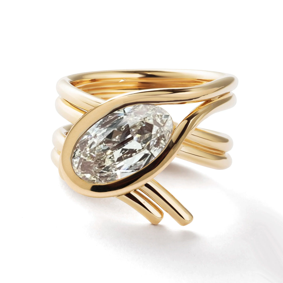 A gold ring with a large oval clear gemstone, featuring a twisted wrap design with multiple bands, shown on a white background.