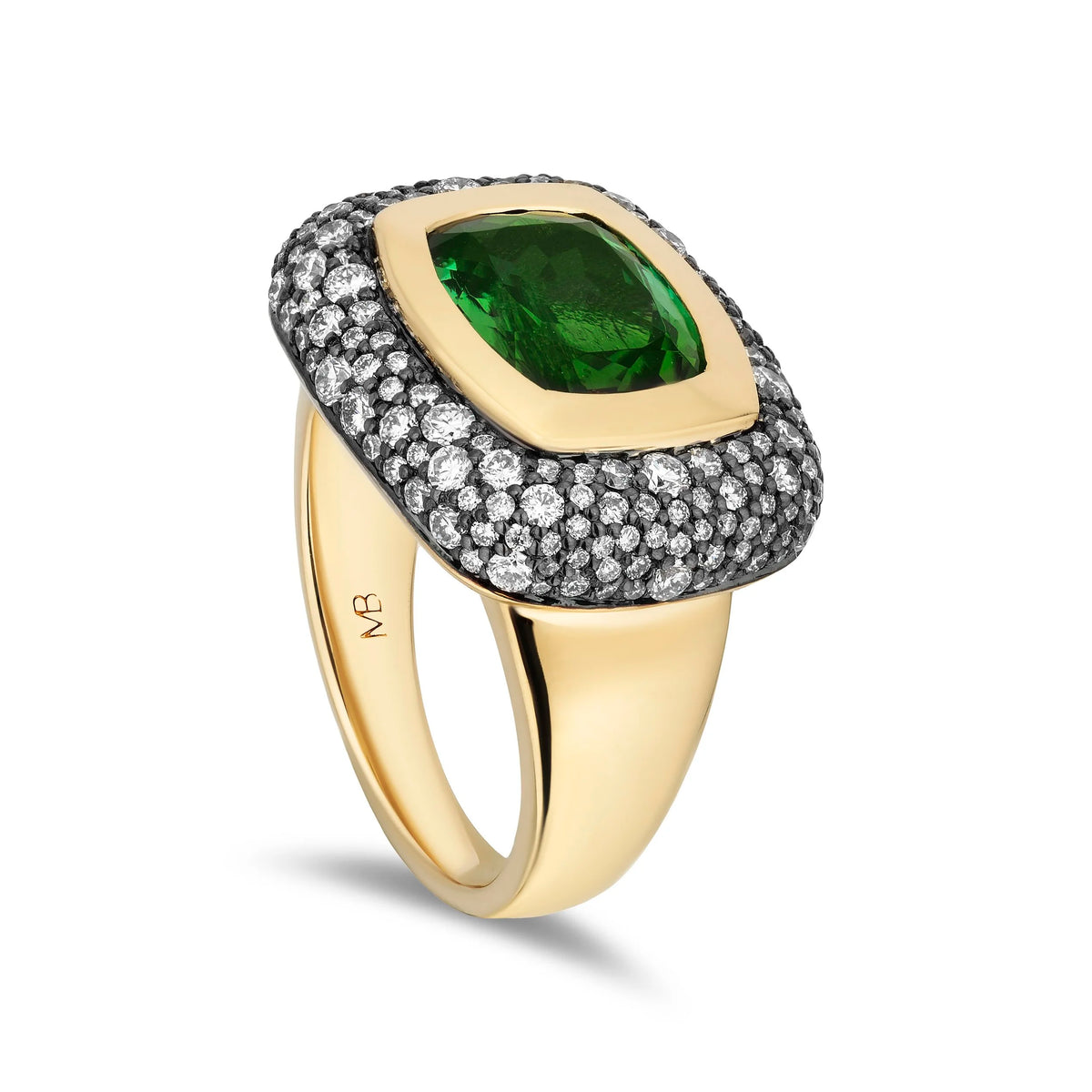 A yellow gold ring featuring a cushion-cut green tourmaline surrounded by a halo of small clear stones, set on a polished gold band with an engraved 'MB' logo.