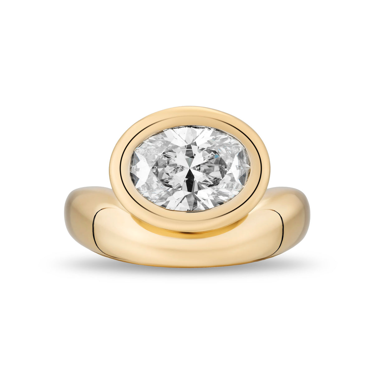 A yellow gold ring featuring a large oval-cut diamond in a bezel setting, with a polished band, shown on a plain white background.