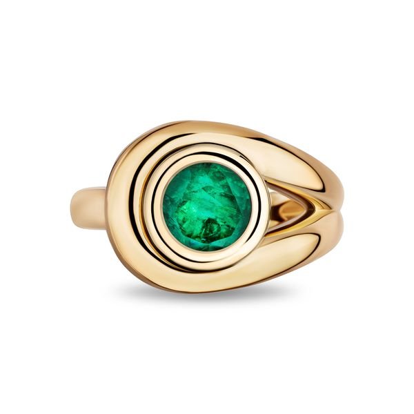 A gold ring featuring a round green emerald, set within concentric oval bezels on a polished split-shank band, shown against a plain white background.