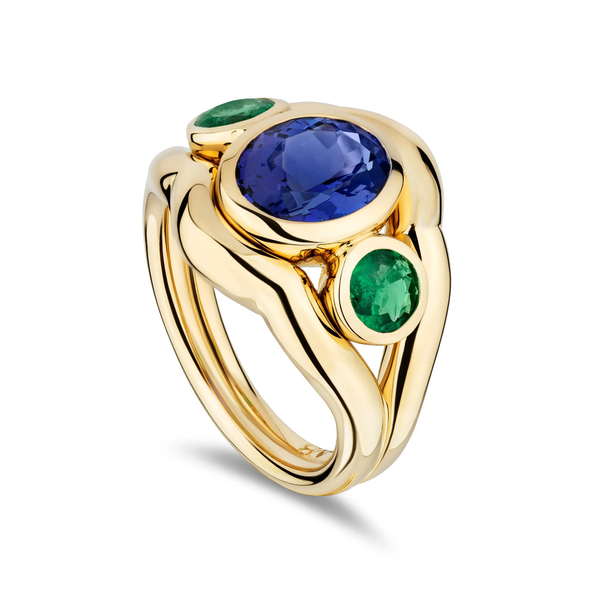 A gold ring featuring a large oval blue sapphire center stone and two round green emerald side stones, set in a sculptural curved gold band on a white background.