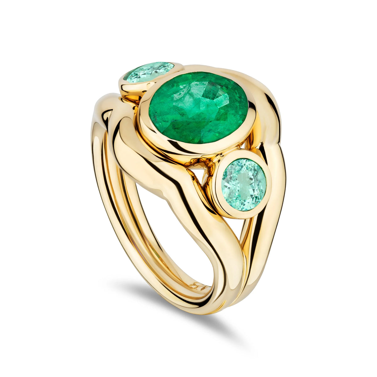A gold ring featuring a large oval emerald green center stone and two smaller round light blue stones, set in a sculptural curved gold band on a white background.