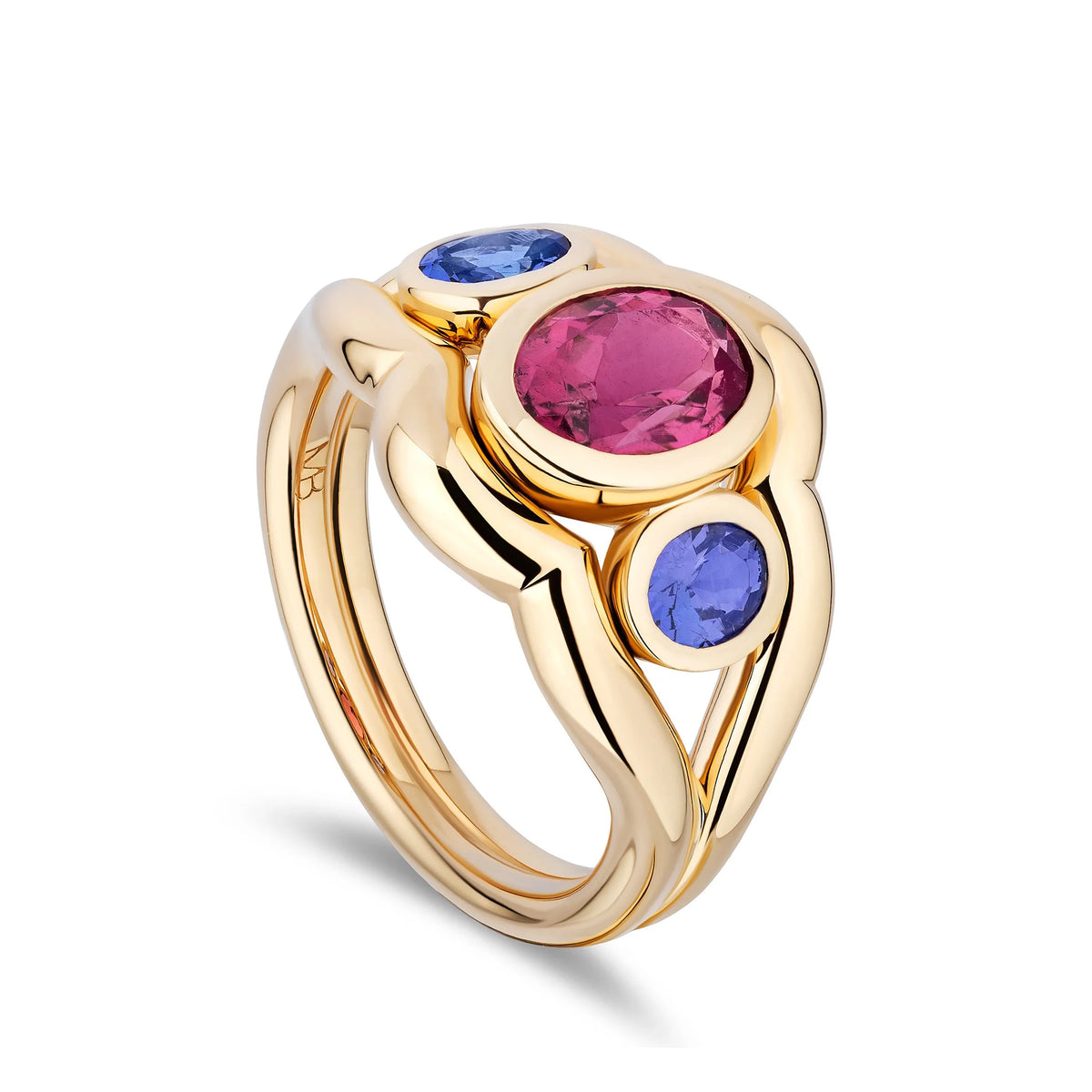 A gold ring with a large oval pink gemstone and two smaller oval blue gemstones, shown on a clean white background.