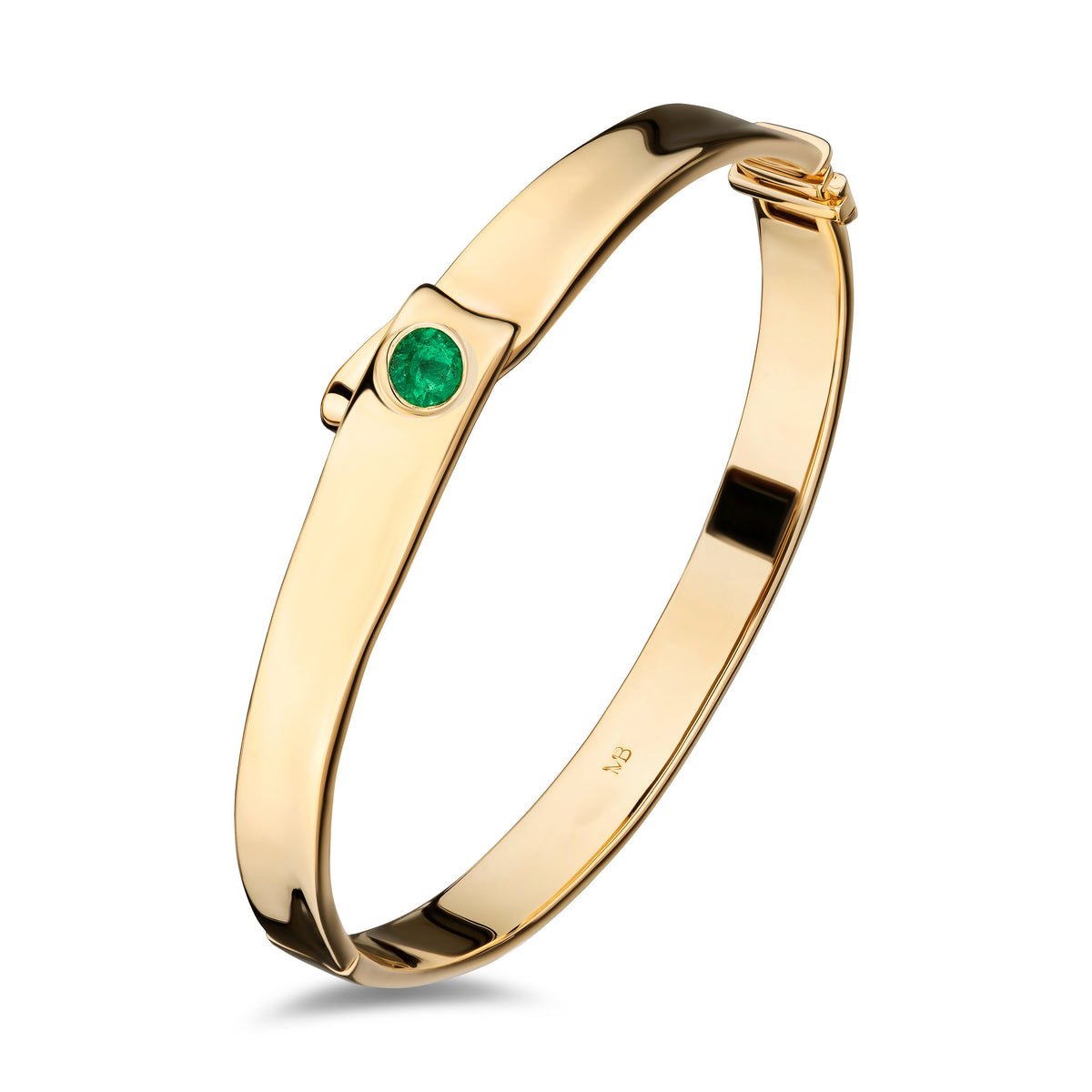 A polished yellow gold bangle bracelet with a single round-cut green gemstone accent on the front, displayed on a clean white background.