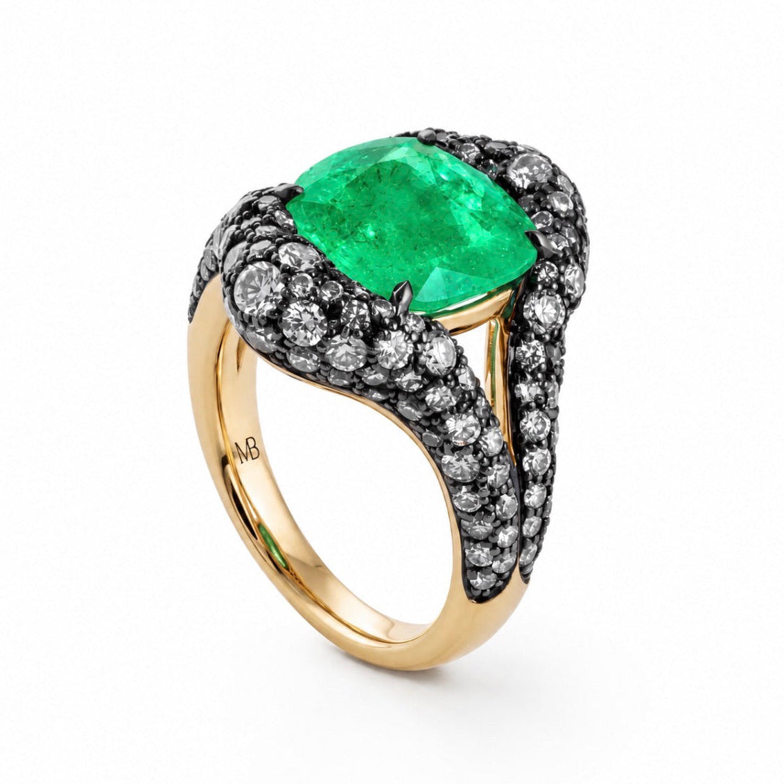 A yellow gold ring featuring a large cushion-cut green emerald gemstone, surrounded by pavé-set black and white diamonds on a clean white background.