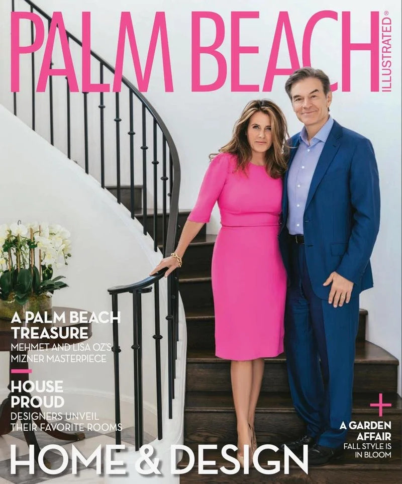 Two people standing on a staircase in an interior setting, a woman in a pink dress and a man in a blue suit.