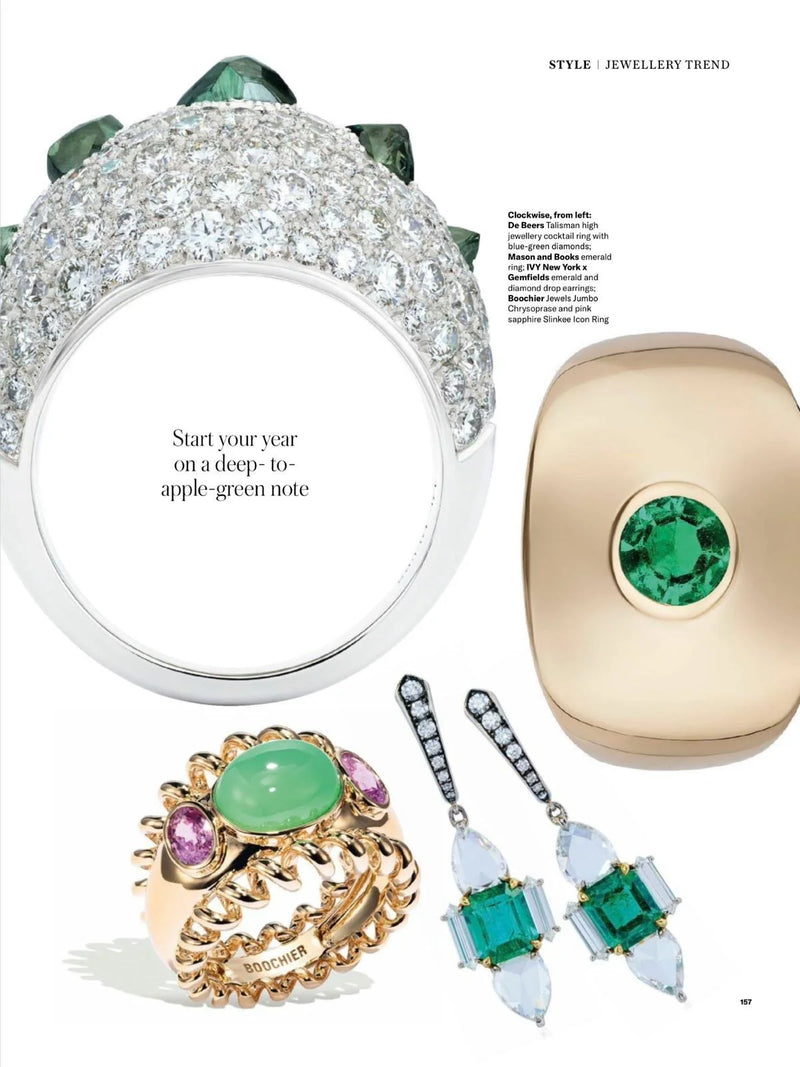 A collection of jewelry including a large diamond and emerald ring, emerald earrings, a green gemstone ring, and a pair of diamond and emerald drop earrings.