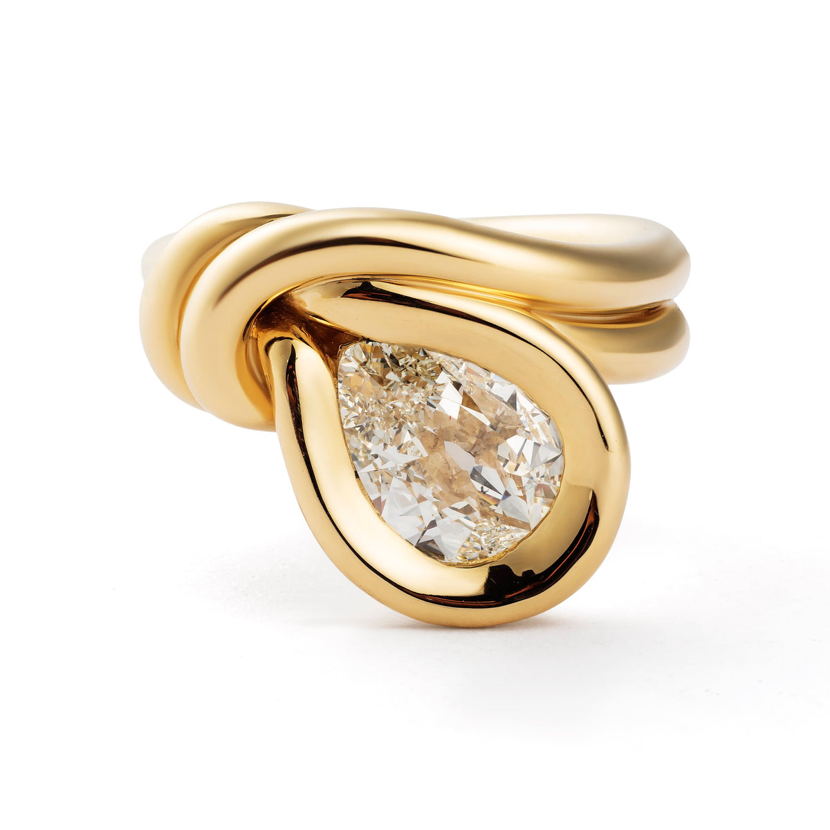 A gold ring featuring a teardrop-shaped clear gemstone in a polished bezel setting, with a sculptural twisted band design, shown on a white background.