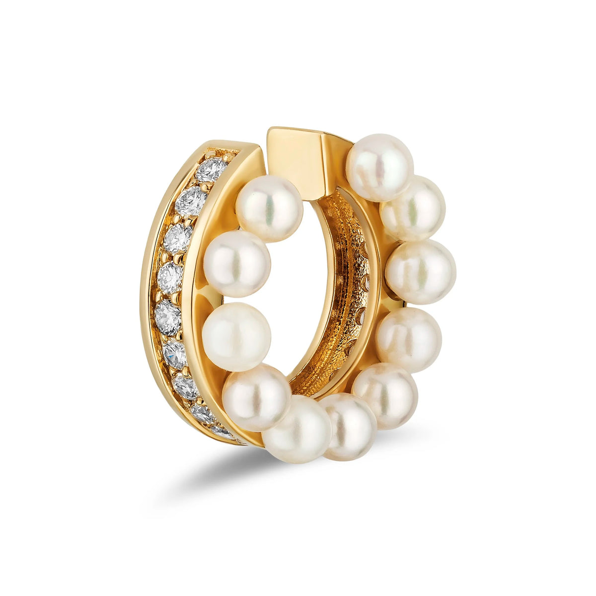 A gold ear cuff earring decorated with a row of white freshwater pearls and a channel of diamonds, shown on a clean white background.