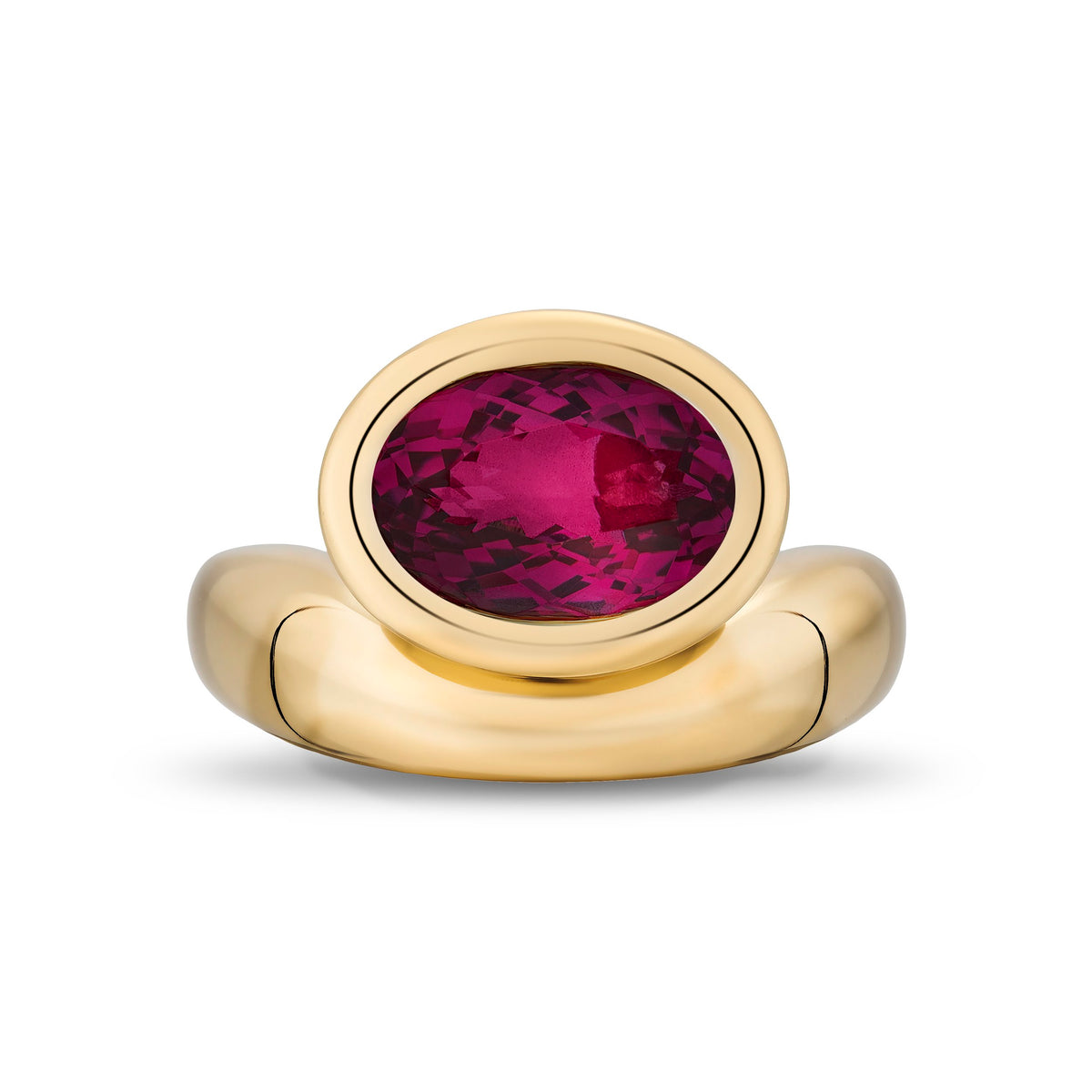 A gold signet-style ring featuring an oval-cut deep rubellite, set against a clean white background.