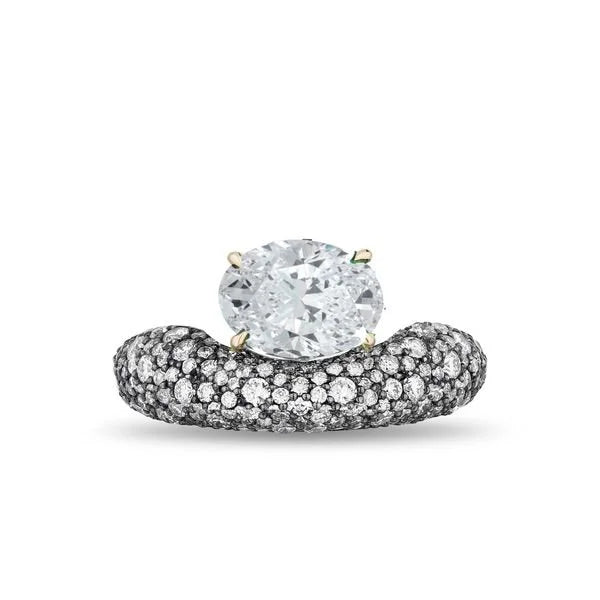 An oval diamond engagement ring featuring a brilliant-cut center stone in a four-prong setting on a curved band paved with small black diamonds, with tiny gold accents at the top of the center stone.