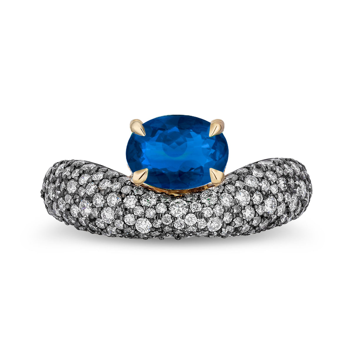 An oval-cut blue sapphire ring set in a yellow gold band paved with small clear stones, shown on a plain white background.