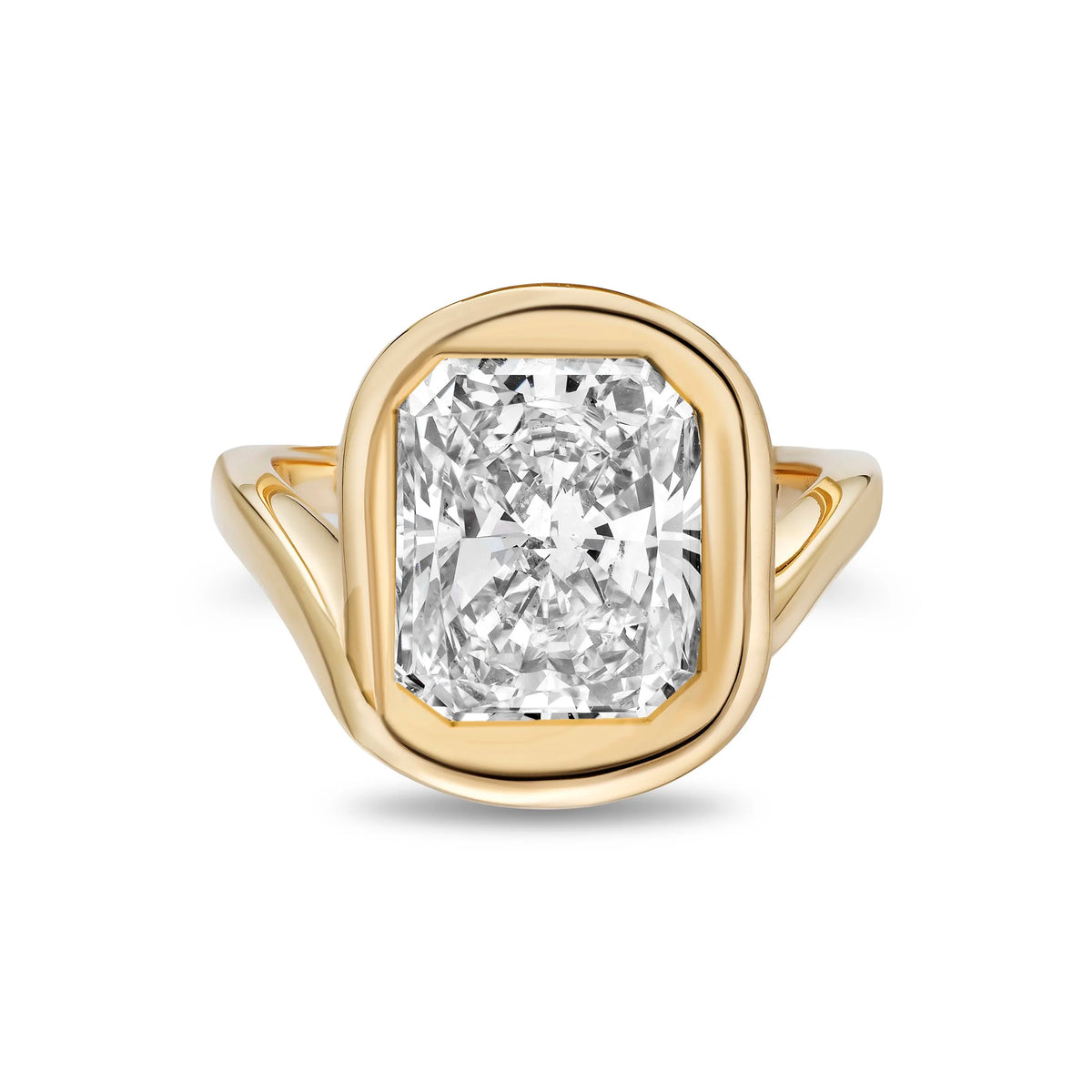 A yellow gold ring featuring a large cushion-cut diamond center stone in a bezel setting, with a split shank band, shown on a plain white background.